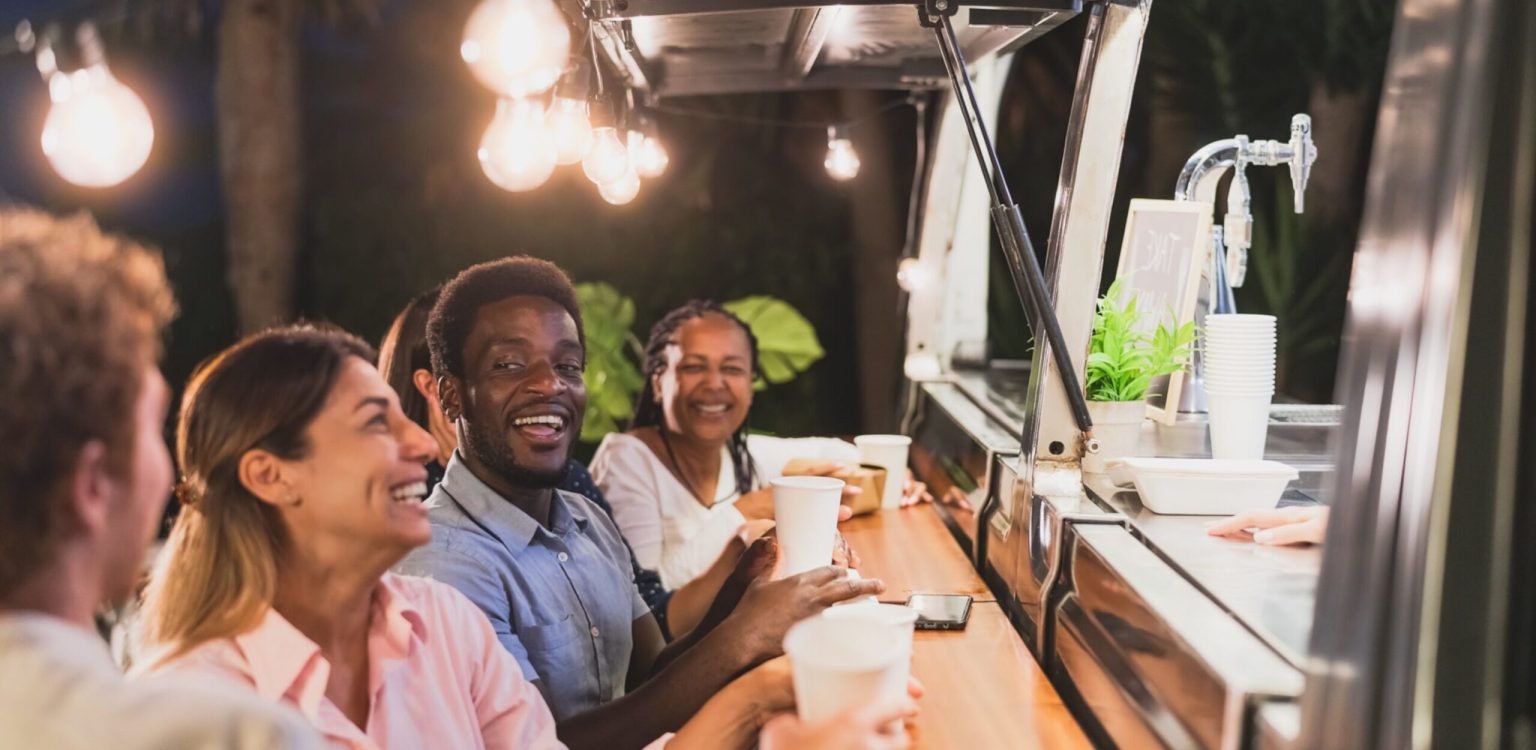 Happy,Multiracial,People,Buying,Meal,From,Food,Truck,Kitchen,-